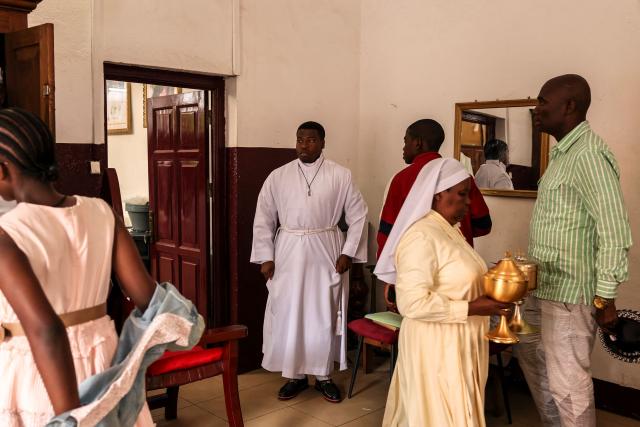 Altar servers prepare in the sacristy of Notre Dame des Victoires Cathedral before the start of Easter Mass in Yaounde on April 5, 2026. (Photo by Daniel BELOUMOU OLOMO / AFP)