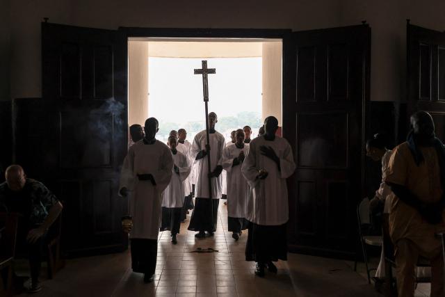 Altar servers process into Notre Dame des Victoires Cathedral during Easter Mass in Yaounde on April 5, 2026. (Photo by Daniel BELOUMOU OLOMO / AFP)