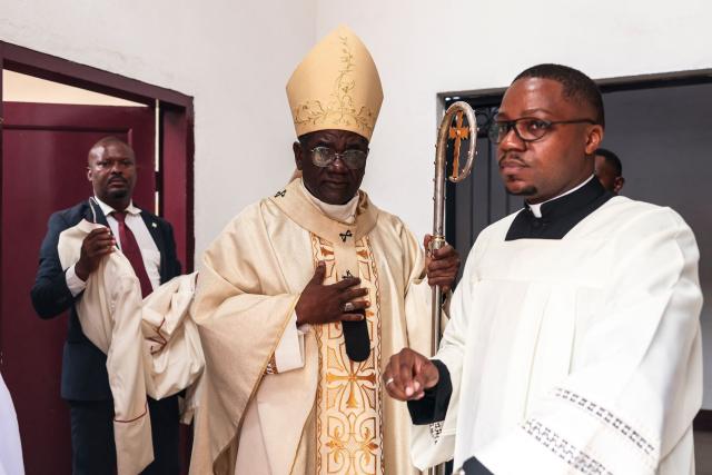 Archbishop of Yaounde Jean Mbarga (C) exits the sacristy of Notre Dame des Victoires Cathedral before the start of Easter Mass in Yaounde on April 5, 2026. (Photo by Daniel BELOUMOU OLOMO / AFP)