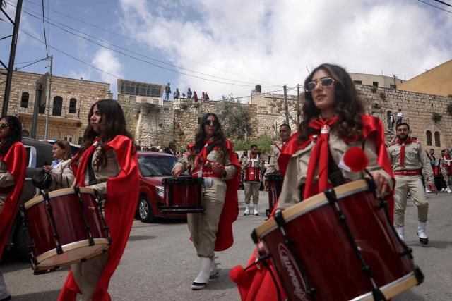 Scouts march in a procession outside the Latin Church in the mostly Christian town of Taybeh, in the Israeli-occupied West Bank on Orthodox Palm Sunday on April 5, 2026. (Photo by Zain JAAFAR / AFP)