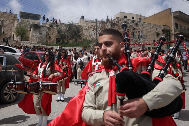 Scouts march in a procession outside the Latin Church in the mostly Christian town of Taybeh, in the Israeli-occupied West Bank on Orthodox Palm Sunday on April 5, 2026. (Photo by Zain JAAFAR / AFP)