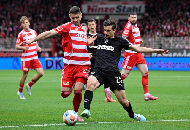 Union Berlin's Serbian forward #23 Andrej Ilic (L) and St Pauli's Polish defender #25 Adam Dzwigala vie for the ball during the German first division Bundesliga football match between Union Berlin and St Pauli in Berlin on April 5, 2026. (Photo by John MACDOUGALL / AFP) / DFL REGULATIONS PROHIBIT ANY USE OF PHOTOGRAPHS AS IMAGE SEQUENCES AND/OR QUASI-VIDEO