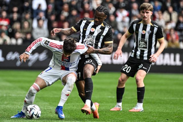 Lyon’s Portuguese forward #17 Afonso Moreira (L) fights for the ball with Angers' French defender #27 Lilian Raolisoa (C) during the French L1 football match between SCO Angers and Olympique Lyonnais (OL) at the Stade Raymond-Kopa in Angers on April 5, 2026. (Photo by Sebastien Salom-Gomis / AFP)
