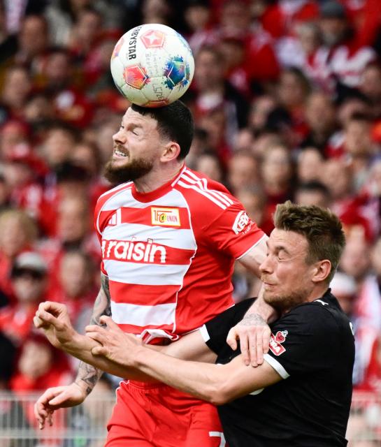 Union Berlin's Scottish forward #07 Oliver Burke (L) and St Pauli's Polish defender #25 Adam Dzwigala vie for the ball during the German first division Bundesliga football match between Union Berlin and St Pauli in Berlin on April 5, 2026. (Photo by John MACDOUGALL / AFP) / DFL REGULATIONS PROHIBIT ANY USE OF PHOTOGRAPHS AS IMAGE SEQUENCES AND/OR QUASI-VIDEO