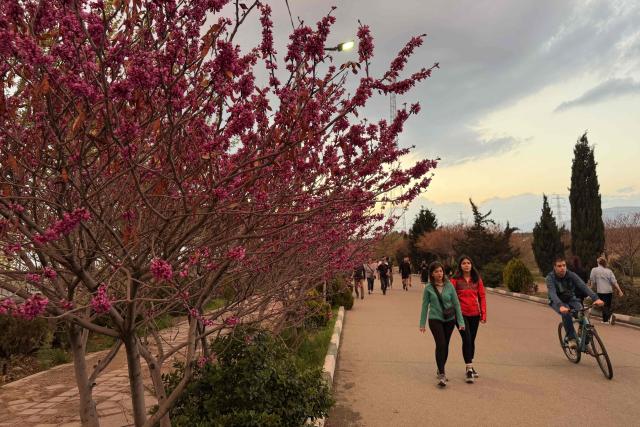 People walk along the Pardisan Park in Tehran on April 5, 2026. The war, which erupted on February 28, 2026 with US-Israeli strikes on Iran, has engulfed the Middle East and convulsed the global economy. (Photo by ATTA KENARE / AFP)