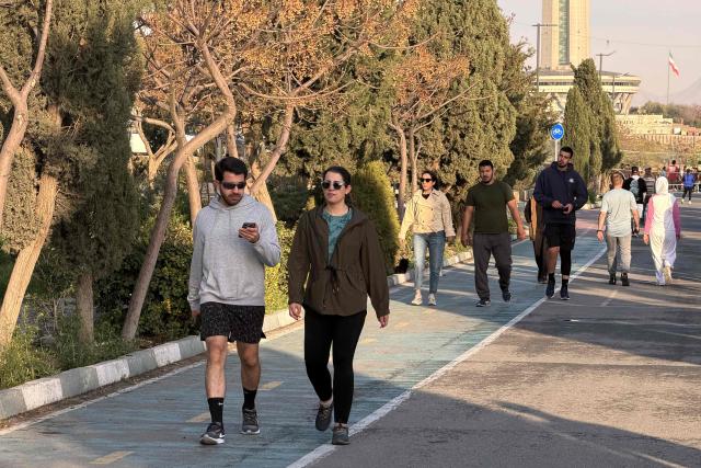 People walk along the Pardisan Park in Tehran on April 5, 2026. The war, which erupted on February 28, 2026 with US-Israeli strikes on Iran, has engulfed the Middle East and convulsed the global economy. (Photo by ATTA KENARE / AFP)