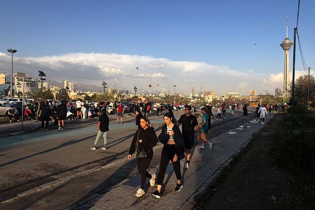 People walk along the Pardisan Park in Tehran on April 5, 2026. The war, which erupted on February 28, 2026 with US-Israeli strikes on Iran, has engulfed the Middle East and convulsed the global economy. (Photo by ATTA KENARE / AFP)