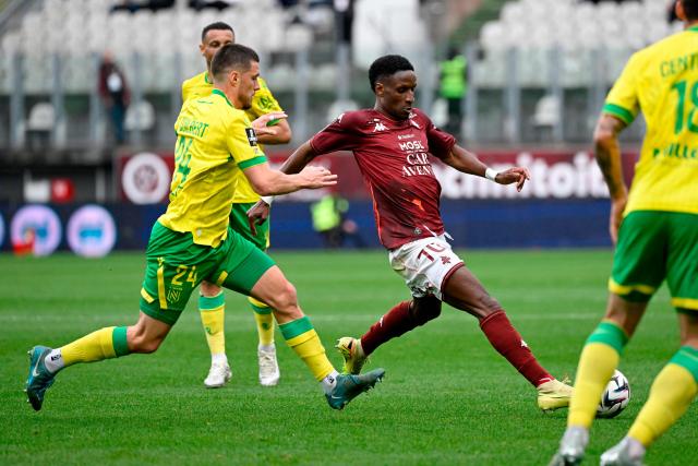 Metz's Senegalese defender #70 Bouna Sarr (R) and Nantes’ French defender #24 Frederic Guilbert (L) fight for the ball during the French L1 football match between FC Metz and FC Nantes  at the Stade Saint-Symphorien in Longeville-les-Metz, eastern France, on April 5, 2026. (Photo by Jean-Christophe VERHAEGEN / AFP)