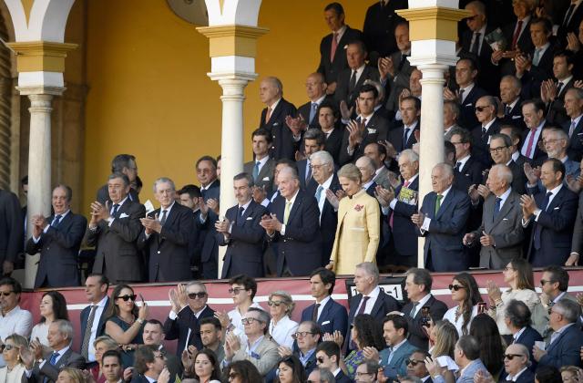 Spain's former King Juan Carlos I (C) flanked by his daughter Elena de Borbon (R) applauds at the beginning of the first bullfight of the season at La Maestranza bullring in Seville on April 5, 2026. (Photo by CRISTINA QUICLER / AFP)