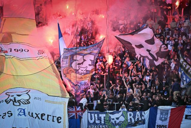Auxerre's supporters burn flares and wave flags before the French L1 football match between Le Havre AC and AJ Auxerre at the Oceane Stadium in Le Havre, Normandy, on April 5, 2026. (Photo by Lou BENOIST / AFP)