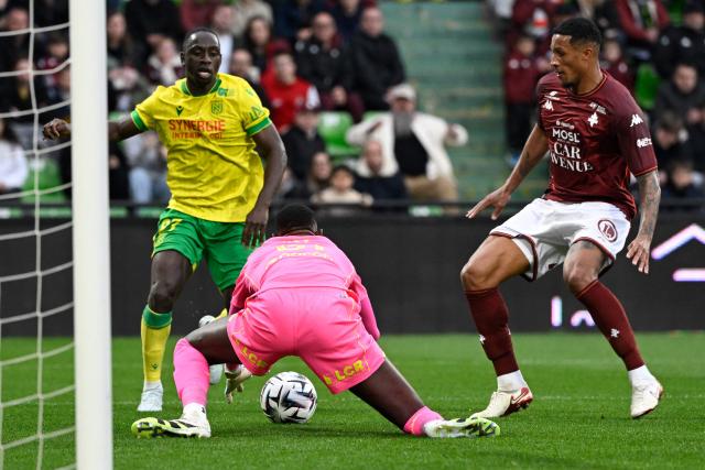 Nantes' Colombian defender #27 Deiver Machado (L) fights for the ball with Metz's Senegalese goalkeeper #61 Pape Sy (C) and Metz's Ivorian midfielder #05 Jean-Philippe Gbamin (R) during the French L1 football match between FC Metz and FC Nantes at the Stade Saint-Symphorien in Longeville-les-Metz, eastern France, on April 5, 2026. (Photo by Jean-Christophe VERHAEGEN / AFP)