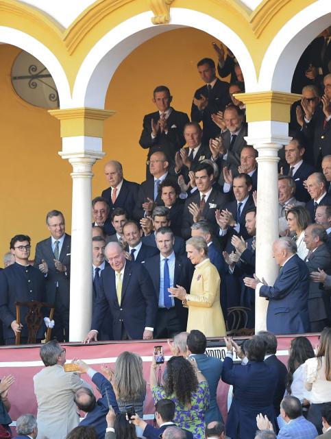 Spain's former King Juan Carlos I (C,L) flanked by his daughter Elena de Borbon (C,R) is applauded during the first bullfight of the season at La Maestranza bullring in Seville on April 5, 2026. (Photo by CRISTINA QUICLER / AFP)