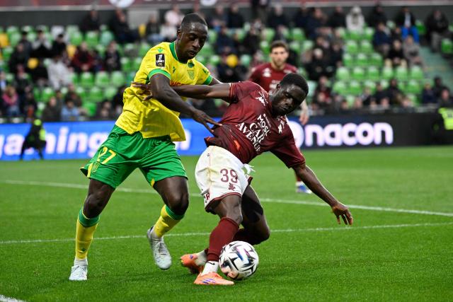 Nantes' Colombian defender #27 Deiver Machado (L) fights for the ball with Metz's Ivorian defender #39 Koffi Kouao (R) during the French L1 football match between FC Metz and FC Nantes at Saint-Symphorien stadium in Longeville-les-Metz, northeastern France, on April 5, 2026. (Photo by Jean-Christophe VERHAEGEN / AFP)