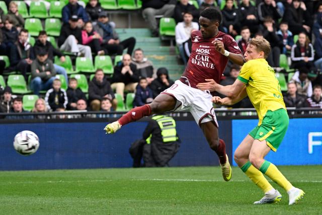 Metz's Senegalese defender #70 Bouna Sarr (L) fights for the ball with Nantes' French defender #03 Nicolas Cozza (R) during the French L1 football match between FC Metz and FC Nantes at Saint-Symphorien stadium in Longeville-les-Metz, northeastern France, on April 5, 2026. (Photo by Jean-Christophe VERHAEGEN / AFP)