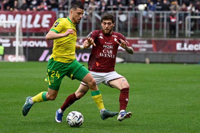 Nantes’ French defender #24 Frederic Guilbert (L) and Metz's Georgian forward #07 Giorgi Tsitaishvili (R) fight for the ball during the French L1 football match between FC Metz and FC Nantes at the Stade Saint-Symphorien in Longeville-les-Metz, eastern France, on April 5, 2026. (Photo by Jean-Christophe VERHAEGEN / AFP)