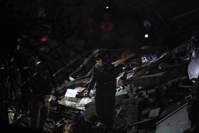 Israeli search and rescue personnel work on the site of a residential building that was destroyed by an Iranian strike in the neighbourhood in Haifa on April 5, 2026. Israeli firefighters were searching for three missing people in the rubble of a residential building in the northern city of Haifa after it was struck by an Iranian missile April 5. The direct hit on a seven-storey building tore through parts of the structure, injuring four people, the military and rescue services said. (Photo by Ilia YEFIMOVICH / AFP) / 