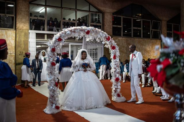 Brides and grooms walk down the aisle during the Easter 2026 mass wedding ceremony at the International Pentecost Holiness Church (IPHC) headquarters in Zuurbekom, Westonaria, on April 5, 2026. (Photo by ILARIA FINIZIO / AFP)