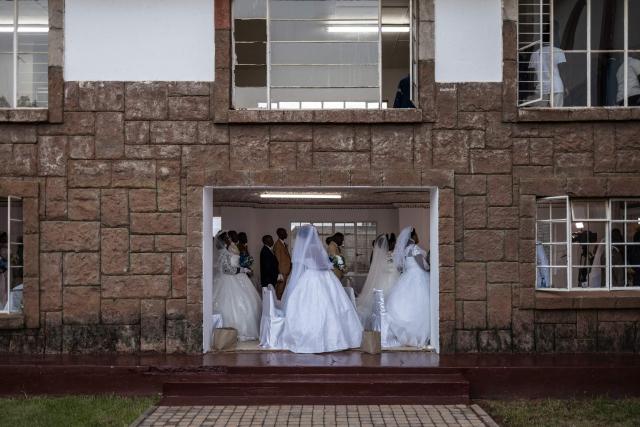 TOPSHOT - Brides and grooms wait to enter the church during the Easter 2026 mass wedding ceremony at the International Pentecost Holiness Church (IPHC) headquarters in Zuurbekom, Westonaria, on April 5, 2026. (Photo by ILARIA FINIZIO / AFP)