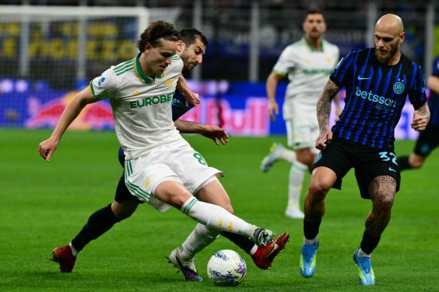 Roma's italian defender #87 Daniele Ghilardi fights for the ball with Inter Milan's Armenian forward #22 Henrikh Mkhitaryan during the Italian Serie A football match between Inter Milan and AS Roma at San Siro stadium in Milan, on April 5, 2026. (Photo by Stefano RELLANDINI / AFP)