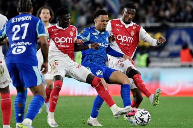 Marseille's English forward #11 Ethan Nwaneri (C) vies with Monaco's Senegalese midfielder #15 Lamine Camara (L) and Monaco's French midfielder #23 Aladji Bamba (R) during the French L1 football match between Monaco (ASM) and Olympique de Marseille (OM) at the Louis II Stadium in Monaco on April 5, 2026. (Photo by Frederic DIDES / AFP)