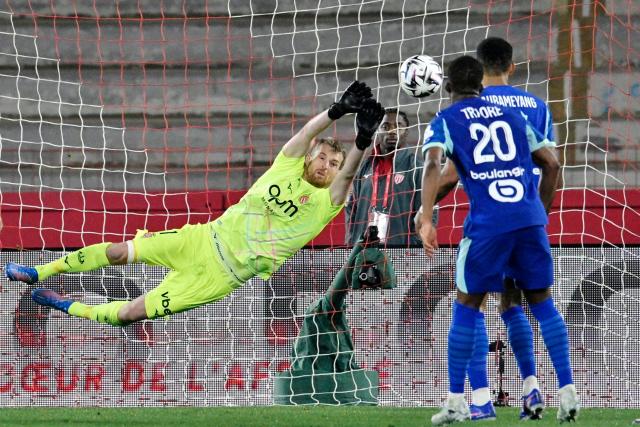 Monaco's Finnish goalkeeper #01 Lukas Hradecky dives for a safe during the French L1 football match between Monaco (ASM) and Olympique de Marseille (OM) at the Louis II Stadium in Monaco on April 5, 2026. (Photo by Frederic DIDES / AFP)