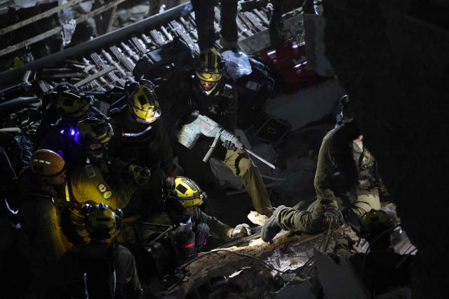 Israeli search and rescue personnel work at the site of a residential building destroyed in an Iranian strike in the northern city of Haifa on April 5, 2026. Israeli firefighters were searching for three missing people in the rubble of a residential building in the northern city of Haifa after it was struck by an Iranian missile April 5. The direct hit on a seven-storey building tore through parts of the structure, injuring four people, the military and rescue services said. (Photo by Ilia YEFIMOVICH / AFP) / 