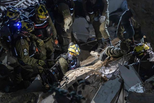 Israeli search and rescue personnel work at the site of a residential building destroyed in an Iranian strike in the northern city of Haifa on April 5, 2026. Israeli firefighters were searching for three missing people in the rubble of a residential building in the northern city of Haifa after it was struck by an Iranian missile April 5. The direct hit on a seven-storey building tore through parts of the structure, injuring four people, the military and rescue services said. (Photo by Ilia YEFIMOVICH / AFP) / 