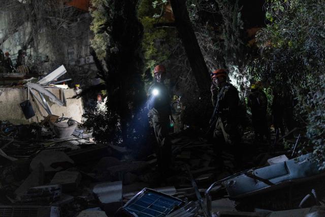 Israeli search and rescue personnel work at the site of a residential building destroyed in an Iranian strike in the northern city of Haifa on April 5, 2026. Israeli firefighters were searching for three missing people in the rubble of a residential building in the northern city of Haifa after it was struck by an Iranian missile April 5. The direct hit on a seven-storey building tore through parts of the structure, injuring four people, the military and rescue services said. (Photo by Ilia YEFIMOVICH / AFP) / 