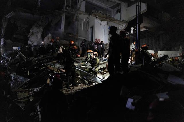 Israeli search and rescue personnel work at the site of a residential building destroyed in an Iranian strike in the northern city of Haifa on April 5, 2026. Israeli firefighters were searching for three missing people in the rubble of a residential building in the northern city of Haifa after it was struck by an Iranian missile April 5. The direct hit on a seven-storey building tore through parts of the structure, injuring four people, the military and rescue services said. (Photo by Ilia YEFIMOVICH / AFP) / 
