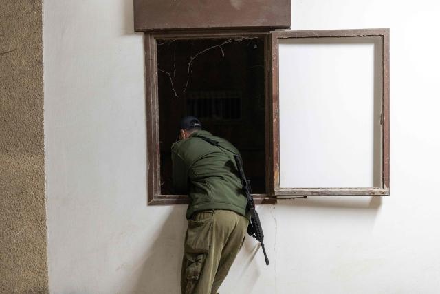 An Israeli soldier overlooks the scene as search and rescue personnel work at the site of a residential building destroyed in an Iranian strike in the northern city of Haifa on April 5, 2026. Israeli firefighters were searching for three missing people in the rubble of a residential building in the northern city of Haifa after it was struck by an Iranian missile April 5. The direct hit on a seven-storey building tore through parts of the structure, injuring four people, the military and rescue services said. (Photo by Ilia YEFIMOVICH / AFP) / 
