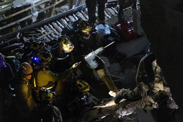 Israeli search and rescue personnel work at the site of a residential building destroyed in an Iranian strike in the northern city of Haifa on April 5, 2026. Israeli firefighters were searching for three missing people in the rubble of a residential building in the northern city of Haifa after it was struck by an Iranian missile April 5. The direct hit on a seven-storey building tore through parts of the structure, injuring four people, the military and rescue services said. (Photo by Ilia YEFIMOVICH / AFP) / 