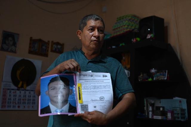 Reynaldo Santos, 58, father of Jonathan Santos, who was previously detained and is now being processed under the state of exception, shows a photograph and a certificate proving his son has no criminal record during an interview with AFP at his home in Soyapango, El Salvador, on March 9, 2026. Mass trials in El Salvador are moving forward against some 91,000 people detained under the state of exception imposed by President Nayib Bukele four years ago, in his anti-gang "war." (Photo by AFP)