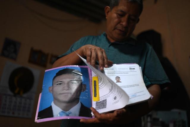 Reynaldo Santos, 58, father of Jonathan Santos, who was previously detained and is now being processed under the state of exception, shows a photograph and a certificate proving his son has no criminal record during an interview with AFP at his home in Soyapango, El Salvador, on March 9, 2026. Mass trials in El Salvador are moving forward against some 91,000 people detained under the state of exception imposed by President Nayib Bukele four years ago, in his anti-gang "war." (Photo by AFP)