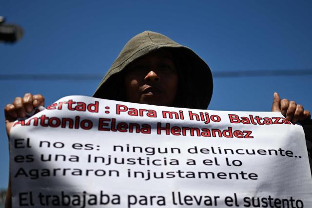 A woman shows a sign demanding the release of her son during a protest against the state of emergency imposed by the government since March 2022, on the 46th anniversary of the assassination of Saint Oscar Arnulfo Romero (1917-1980), in San Salvador on March 24, 2026. Mass trials in El Salvador are moving forward against some 91,000 people detained under the state of exception imposed by President Nayib Bukele four years ago, in his anti-gang "war." (Photo by AFP)