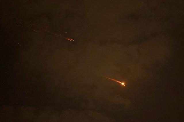 Rocket trails are seen in the sky above the Israeli coastal city of Netanya amid a fresh barrage of Iranian missile attacks on April 6, 2026. The Middle East was sparked by joint US-Israeli strikes on Iran that triggered a wave of retaliatory missile and drone attacks against Israel and several other countries in the region. (Photo by JACK GUEZ / AFP) / 