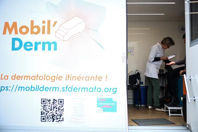 Dermatologist Blandine De Carrere conducts a consultation in an itinerant truck as part of the Mobil Derm project supported by the Societe Francaise de Dermatologie (French Dermatology Society) at a parking lot in Lafox, south-western France, on April 2, 2026. As in the rest of France, patients suffering from skin diseases are facing significant delays in receiving care in Nouvelle-Aquitaine, with loss of chances in the most serious cases. In Lafox, 25 patients a day enter the few square meters of the mobile clinic, where a dermatologist from the Basque Country has come for two days to carry out consultations in her free time  a pioneering system in France intended to compensate for the shortage of dermatologists and address medical deserts. (Photo by Christophe ARCHAMBAULT / AFP)