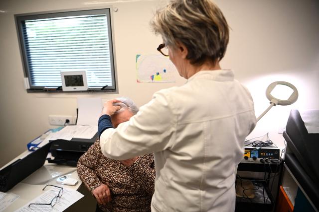 Dermatologist Blandine De Carrere conducts a consultation in an itinerant truck as part of the Mobil Derm project supported by the Societe Francaise de Dermatologie (French Dermatology Society) at a parking lot in Lafox, south-western France, on April 2, 2026. As in the rest of France, patients suffering from skin diseases are facing significant delays in receiving care in Nouvelle-Aquitaine, with loss of chances in the most serious cases. In Lafox, 25 patients a day enter the few square meters of the mobile clinic, where a dermatologist from the Basque Country has come for two days to carry out consultations in her free time  a pioneering system in France intended to compensate for the shortage of dermatologists and address medical deserts. (Photo by Christophe ARCHAMBAULT / AFP)