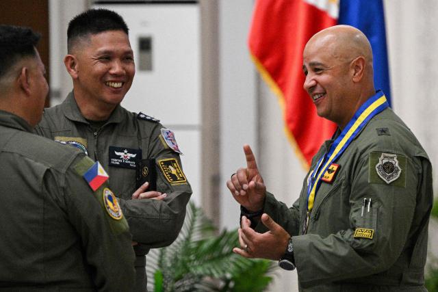 US Air Force Brigadier General Phillip Mallory (R), Pacific Air Force head of delegation, talks to Philippine Air Force officers during the opening ceremony of the COPE Thunder exercise at Clark air base in Angeles city, Pampanga province on April 6, 2026. (Photo by Ted ALJIBE / AFP)