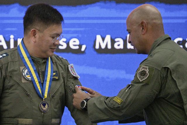 US Air Force Brigadier General Phillip Mallory (R), Pacific Air Force head of delegation, places the exercise patch on Philippine Major General Dennis Estrella, commander of Air logistics command, during the opening ceremony of the COPE Thunder exercise at Clark air base in Angeles city, Pampanga province on April 6, 2026. (Photo by Ted ALJIBE / AFP)