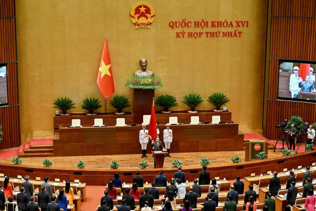 Vietnam's newly elected National Assembly Chairman Tran Thanh Man (C) takes his oath during the opening session of the National Assembly in Hanoi on April 6, 2026. (Photo by -STR / AFP)