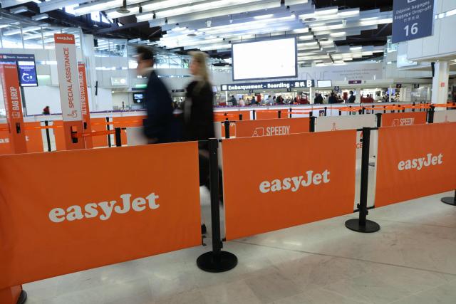 People walk at the EasyJet check-in counter while some of the airline's staff are on strike at Orly Airport, in the Paris suburbs, on April 6, 2026. (Photo by Thomas SAMSON / AFP)