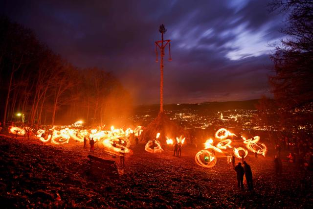 Participants wave burning torches before lighting the Easter fire on a hill in Attendorn, western Germany on April 5, 2026. Easter fires are traditionally lit all over Germany on Holy Saturday and Easter Sunday. In Attendorn, Easter fires with huge crosses are burned on four hills. In addition, burning torches are waved, with which fire circles are painted in the air. (Photo by Ina FASSBENDER / AFP)