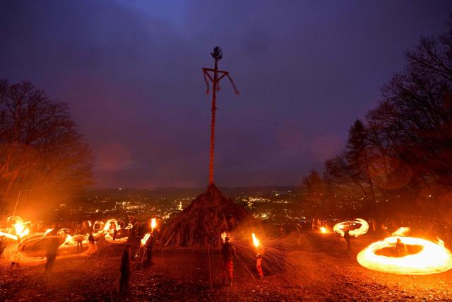 Participants wave burning torches before lighting the Easter fire on a hill in Attendorn, western Germany on April 5, 2026. Easter fires are traditionally lit all over Germany on Holy Saturday and Easter Sunday. In Attendorn, Easter fires with huge crosses are burned on four hills. In addition, burning torches are waved, with which fire circles are painted in the air. (Photo by Ina FASSBENDER / AFP)