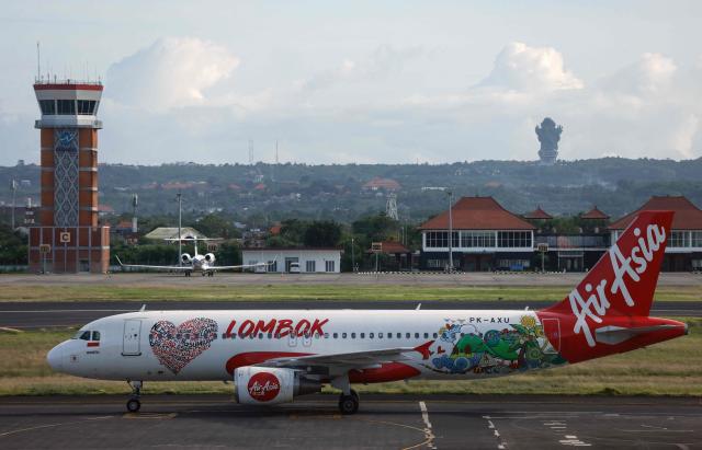 (FILES) An AirAsia Airbus A320 passenger aircraft taxis after landing at the I Gusti Ngurah Rai International Airport in Bali on January 21, 2024. Indonesia announced on April 6, 2026 a 28-percentage point rise in the surcharge on jet fuel, and said it will allow airlines to raise the domestic ticket price, which the government caps, by up to 13 percent. (Photo by David GANNON / AFP)