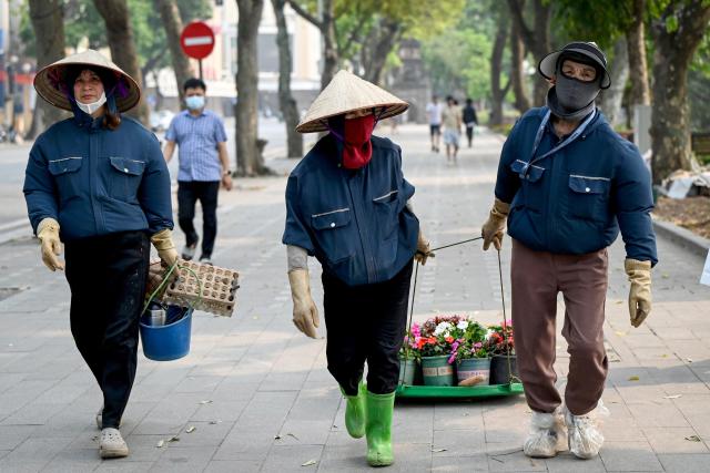 Workers drag flower pots along Hoan Kiem Lake in Hanoi on April 6, 2026. (Photo by Nhac NGUYEN / AFP)