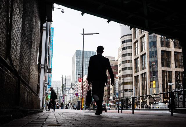A businessman walks under a rail line to a metro station at the end of the workday in Tokyo's Ginza district on April 6, 2026. (Photo by Andrew CABALLERO-REYNOLDS / AFP)
