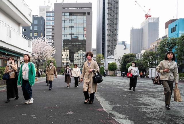 A group of women walk through a park at the end of the workday in Tokyo's Ginza district on April 6, 2026. (Photo by Andrew CABALLERO-REYNOLDS / AFP)