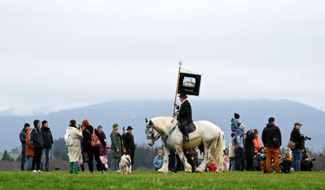Spectators watch as a participant on horseback rides during the traditional St George's Cavalcade (Georgiritt) in Traunstein, southern Germany on Easter Monday on April 6, 2026. The annual ride is a horse pilgrimage to honor Saint George and takes the participants from the Bavarian town of Traunstein to the chapel of Ettendorf, where they are blessed. (Photo by Christof STACHE / AFP)