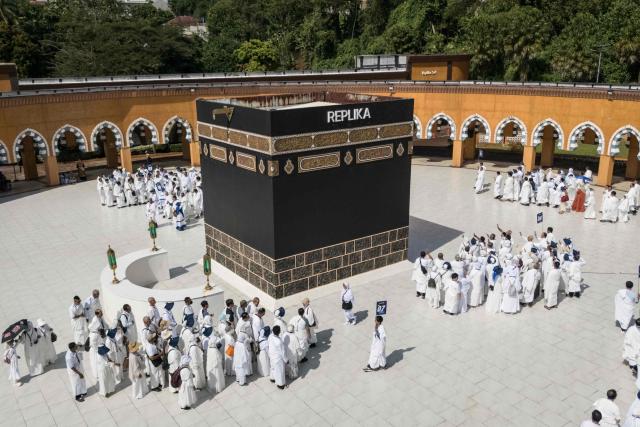An aerial image shows prospective Indonesian pilgrims practicing circumambulation rituals around a replica of the Kaaba, Islam’s holiest shrine, during a training session at the Al Mahmudah Manasik Training Center (AMTC) in South Tangerang on April 5, 2026. The centre provides a simulated experience of Mecca’s pilgrimage sites ahead of the Hajj season in late May. Indonesia, home to the world’s largest Muslim population, has been allocated a Hajj quota of 221,000 pilgrims for 2026, but faces long waiting lists that can stretch for decades in some regions. (Photo by AFP)