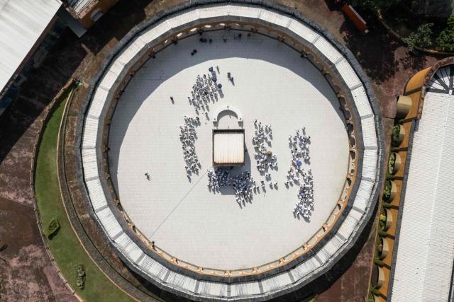 An aerial image shows prospective Indonesian pilgrims practicing circumambulation rituals around a replica of the Kaaba, Islam’s holiest shrine, during a training session at the Al Mahmudah Manasik Training Center (AMTC) in South Tangerang on April 5, 2026. The centre provides a simulated experience of Mecca’s pilgrimage sites ahead of the Hajj season in late May. Indonesia, home to the world’s largest Muslim population, has been allocated a Hajj quota of 221,000 pilgrims for 2026, but faces long waiting lists that can stretch for decades in some regions. (Photo by AFP)